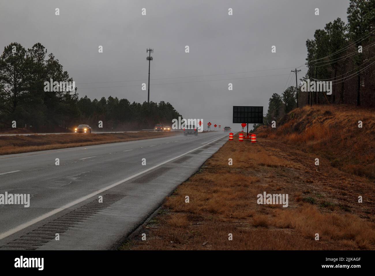 Augusta, GA USA - 01 31 21: Verkehr auf einer Landstraße mit Baukegel und Schildern Stockfoto