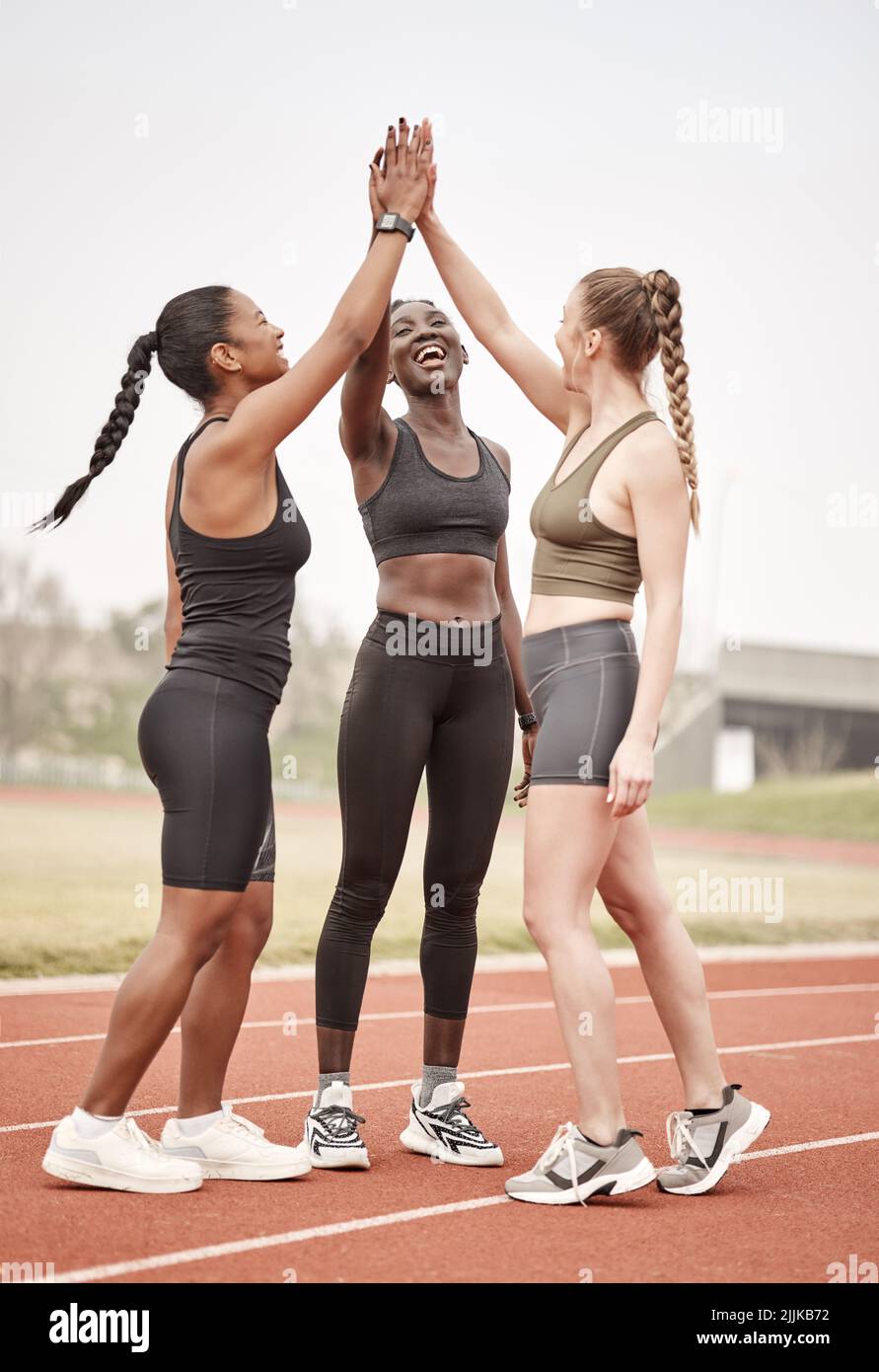 Gemeinsam bilden wir das Traumteam. Eine Gruppe von weiblichen Athleten, die sich gegenseitig hoch fiving. Stockfoto