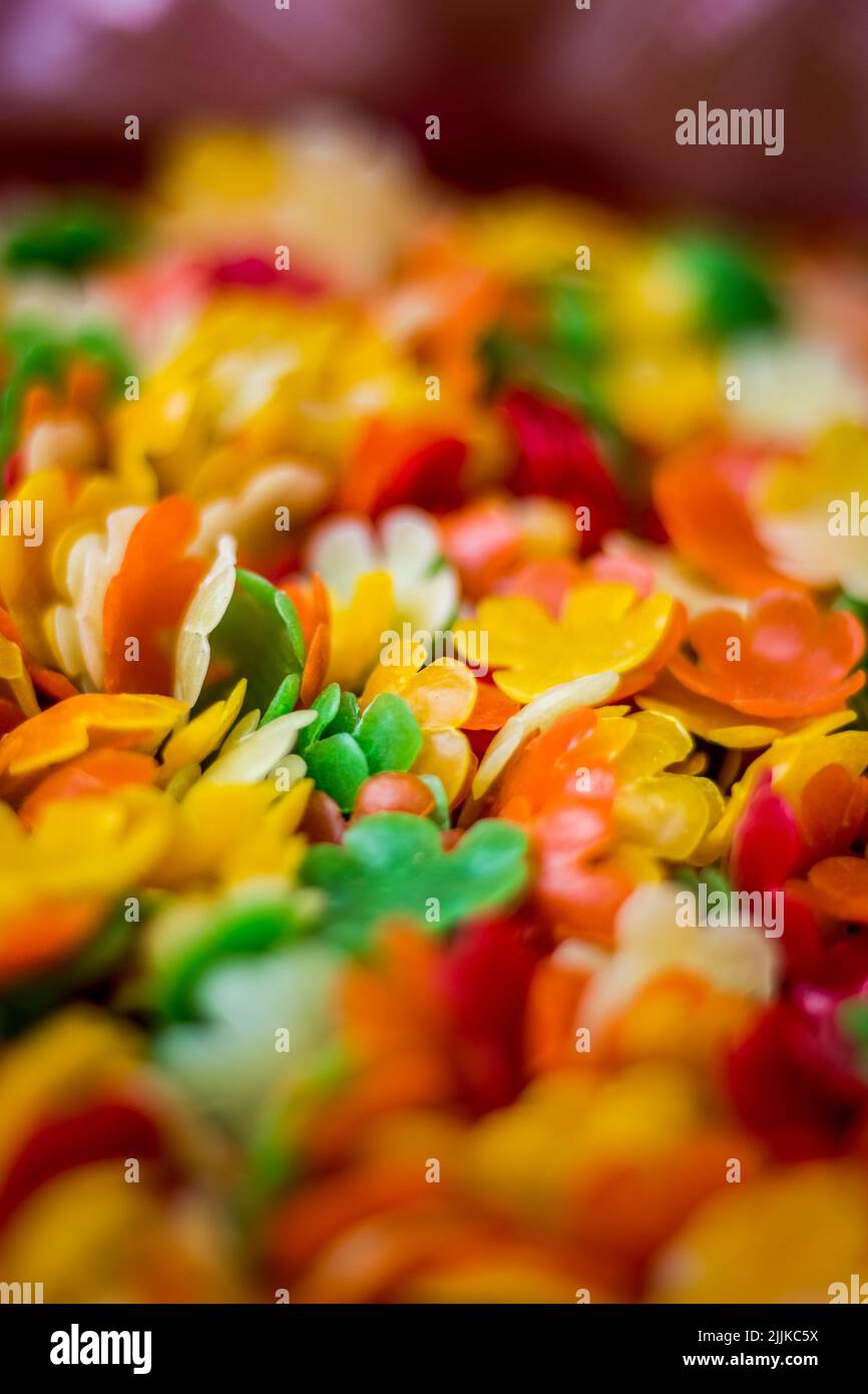 Eine vertikale Nahaufnahme von farbenfrohen, floralen indischen Snacks Stockfoto