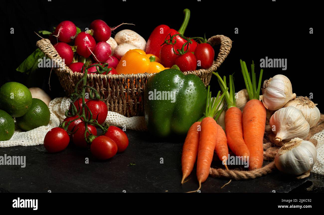 Eine Vielzahl von frischem, dickem Gemüse in Körben auf schwarzem Hintergrund Stockfoto