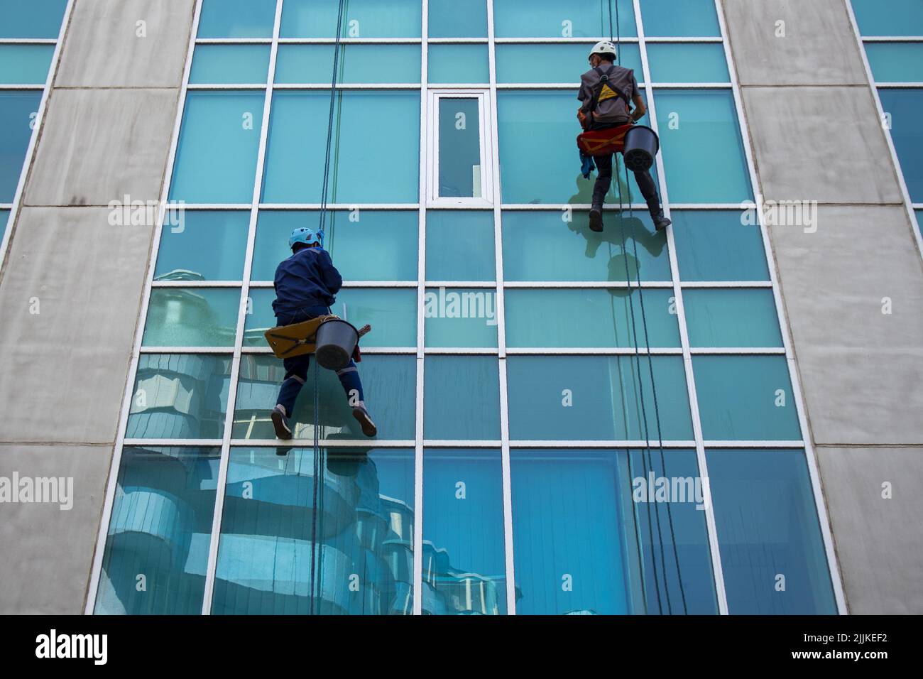 Zwei Industriekletterer waschen Fenster. Einen Wolkenkratzer waschen Stockfoto