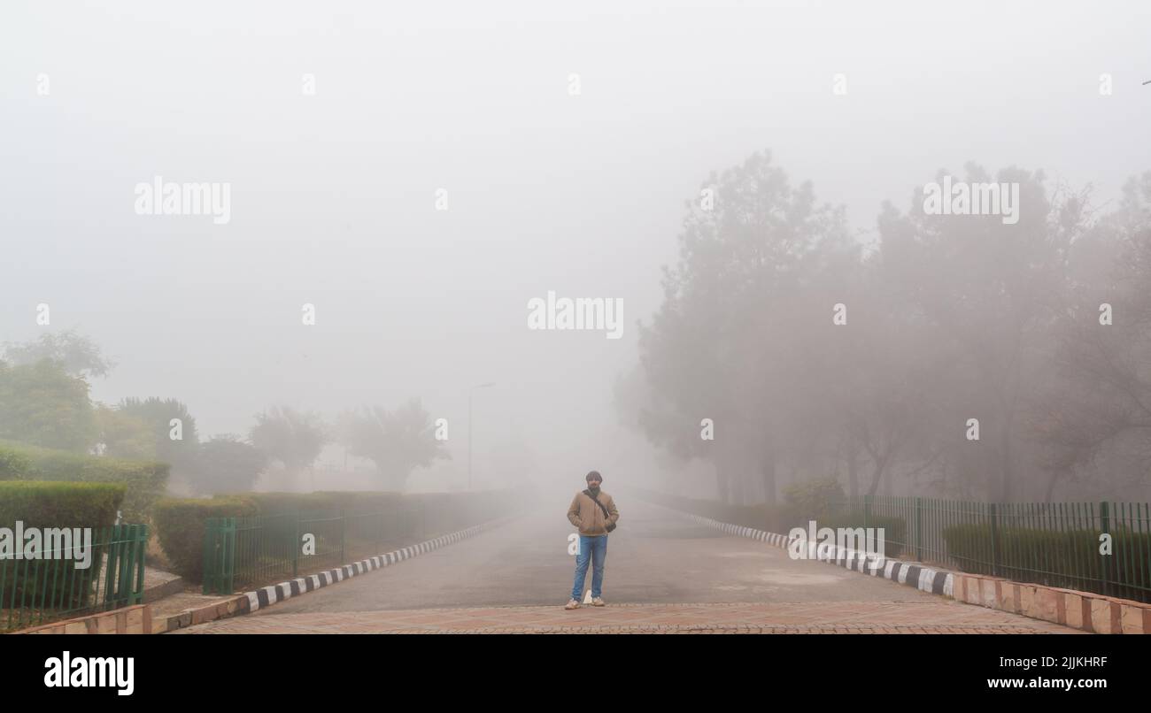 Ein südasiatischer Mann, der an einem nebligen Wintertag den Blick auf die Natur genießt Stockfoto