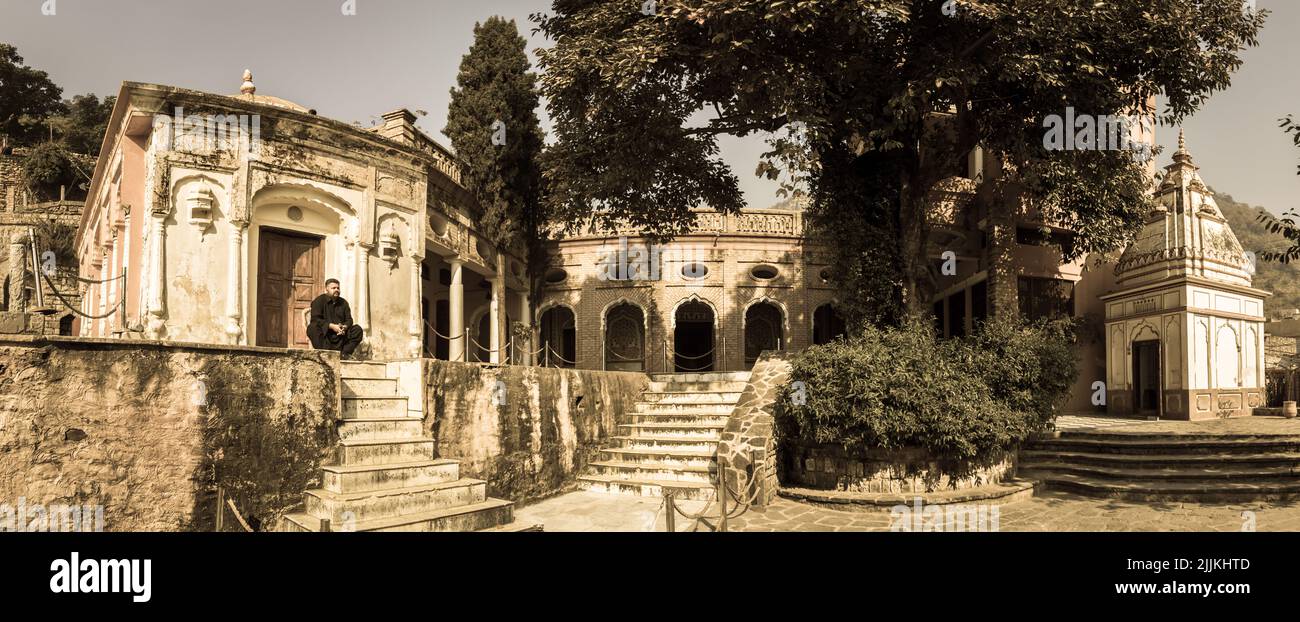 Ein junger Mann, der neben einem alten Sikh-Tempel in Islamabad, Pakistan, sitzt Stockfoto