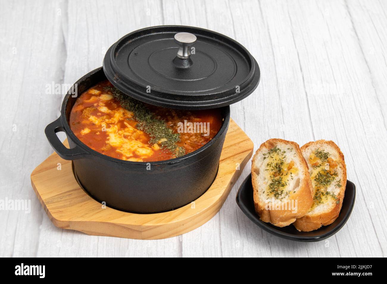 Eine schräge Aufnahme einer Suppe, die in einem kleinen Topf neben Bruschetta-Brotscheiben serviert wird. Stockfoto
