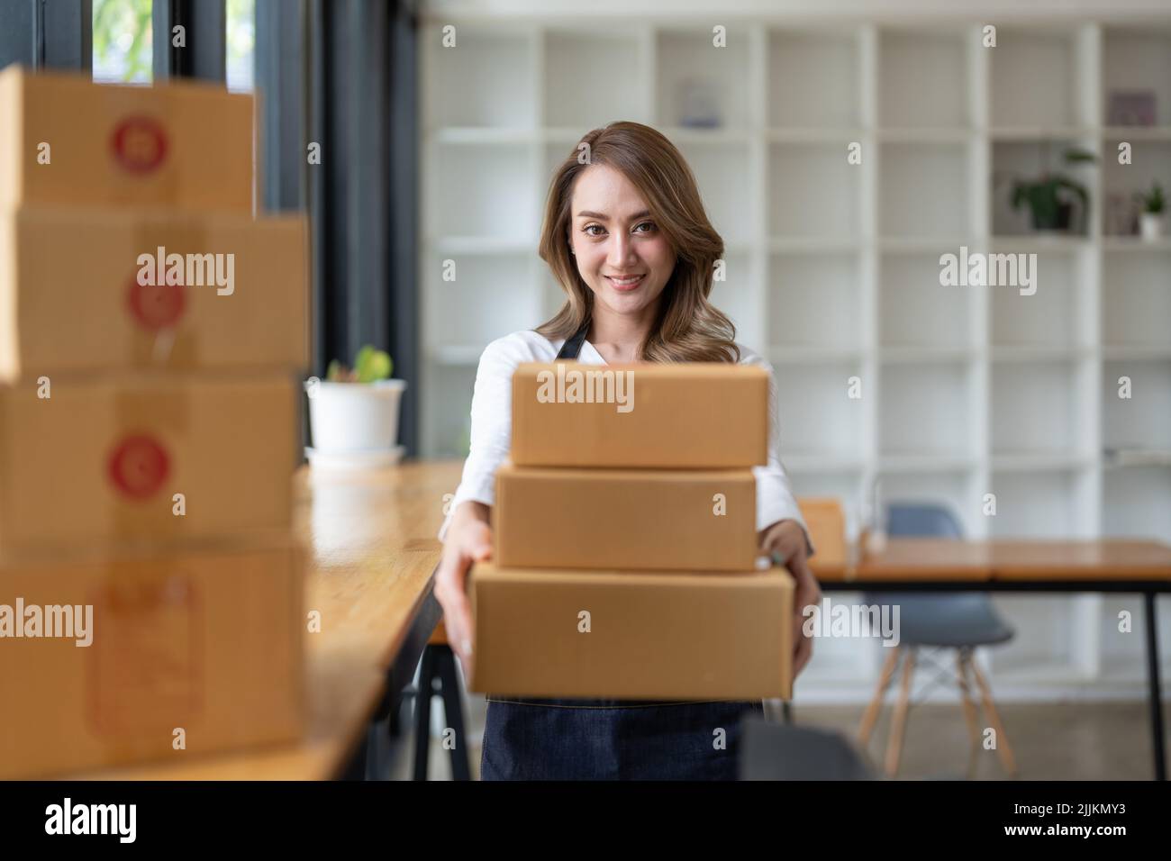 Junge asiatische Frau Freiberufler kmu-Geschäft Online-Shopping Arbeiten mit Paketbox zu Hause - KMU-Geschäft Online-und Lieferkonzept Stockfoto