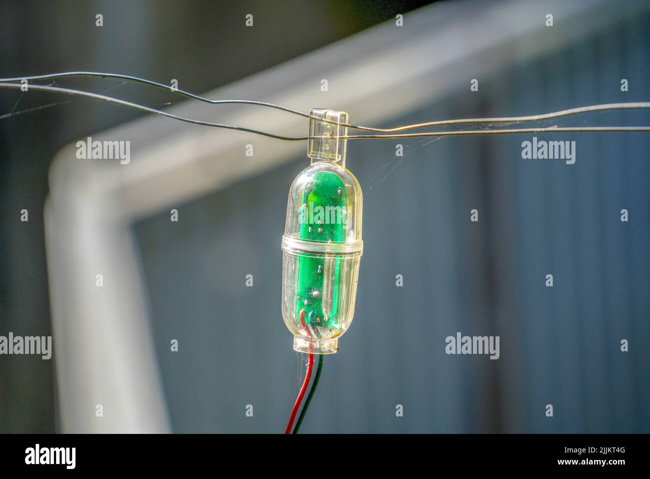 Nahaufnahme eines raffinierten Alarmsystems, das an einen Drahtzaun angeschlossen ist Stockfoto