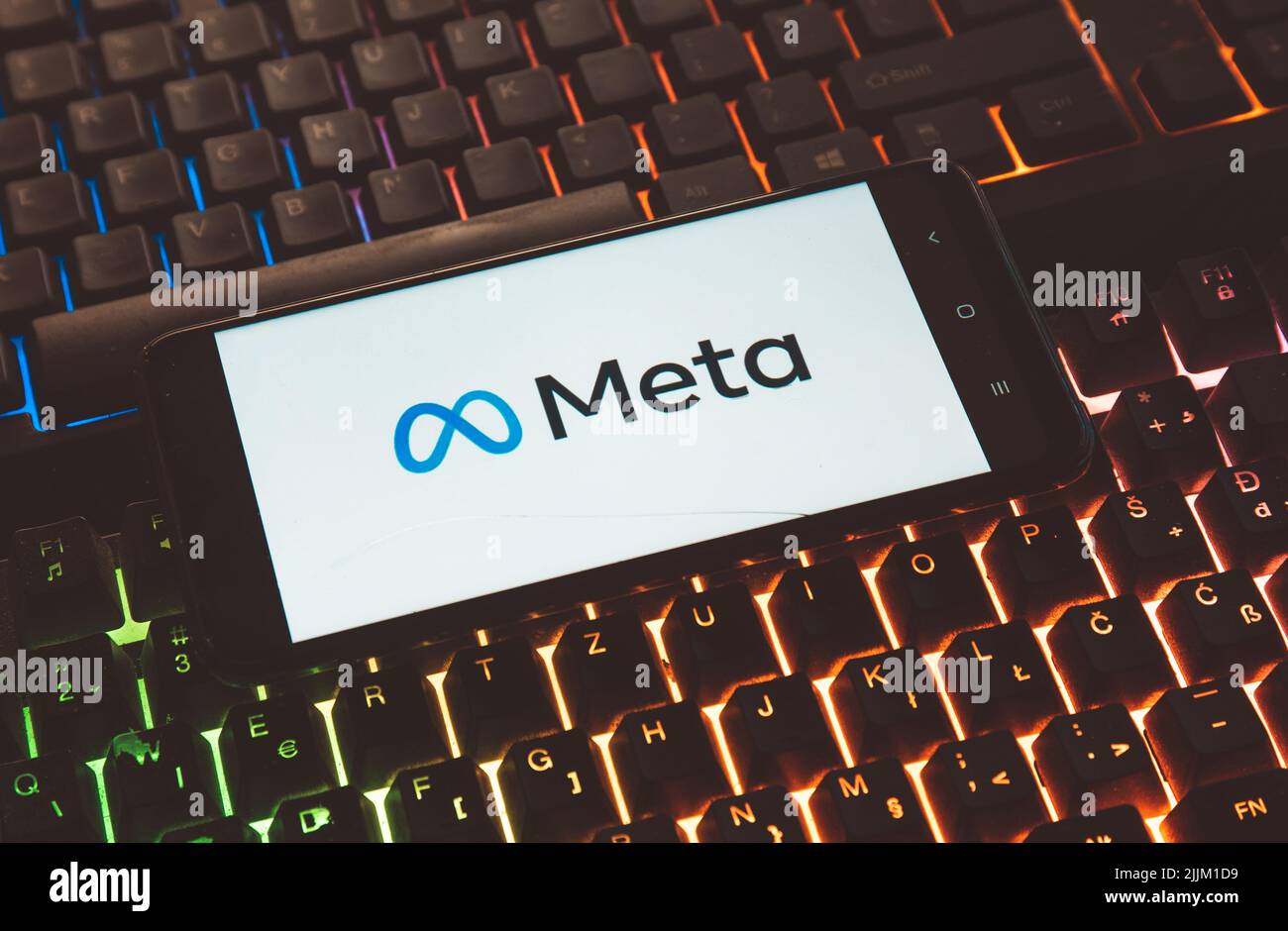 Eine Nahaufnahme eines Meta-Logos auf dem Bildschirm eines Mobiltelefons auf einer Laptop-Tastatur Stockfoto