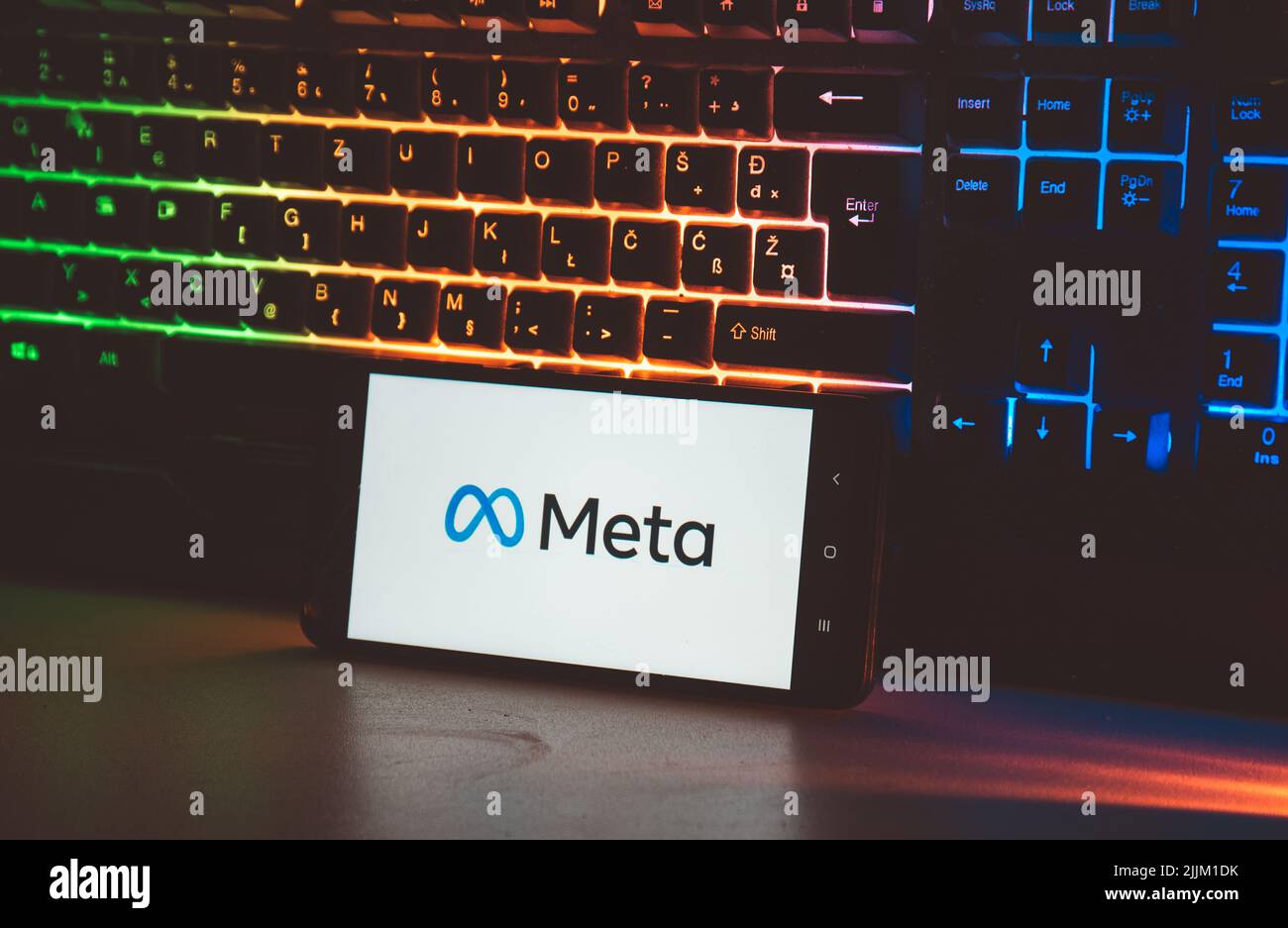 Eine Nahaufnahme eines Meta-Logos auf dem Bildschirm eines Mobiltelefons gegen die Computertastatur Stockfoto