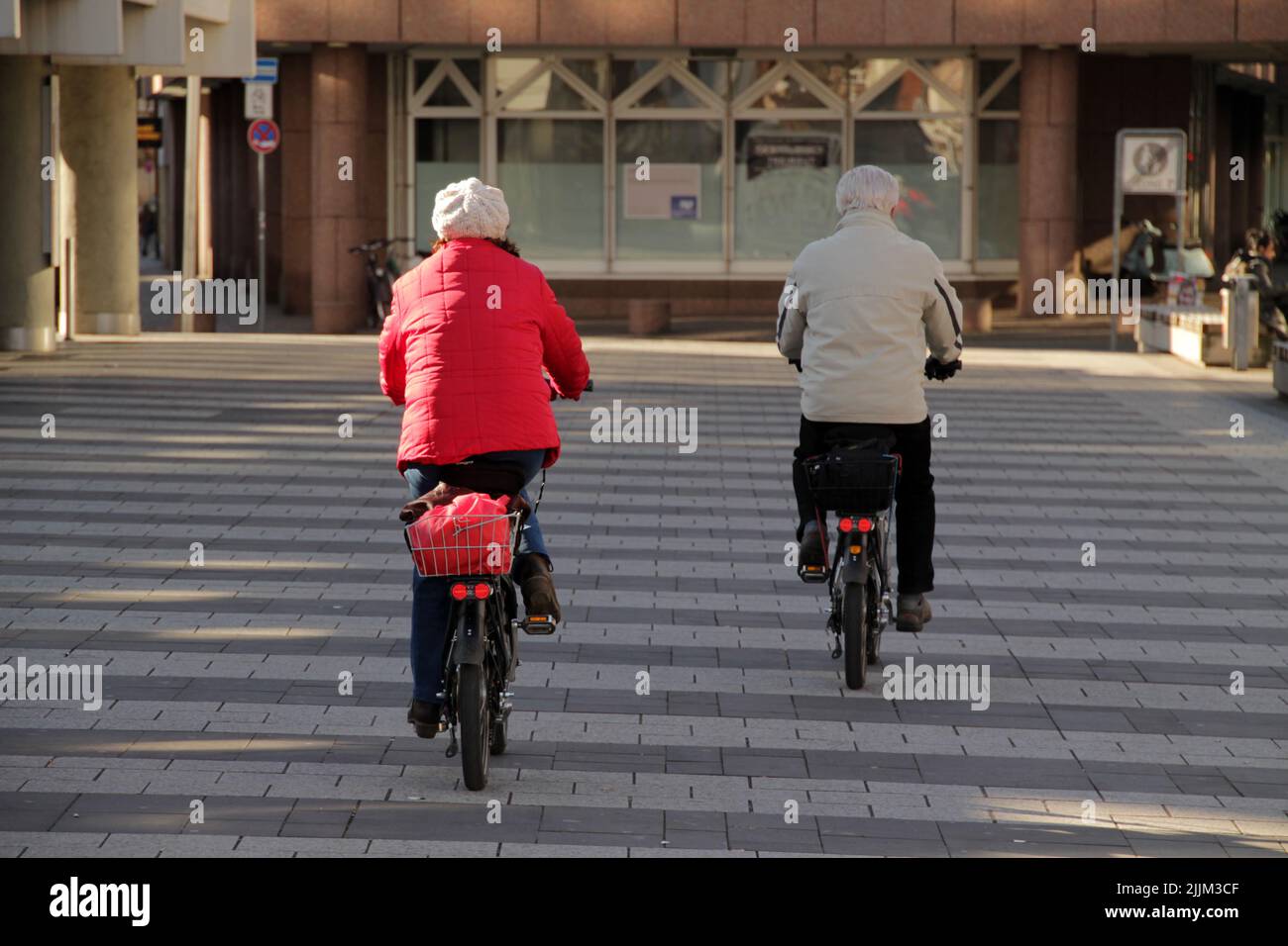 Zwei Erwachsene, die auf der Straße Rad fahren. Stockfoto