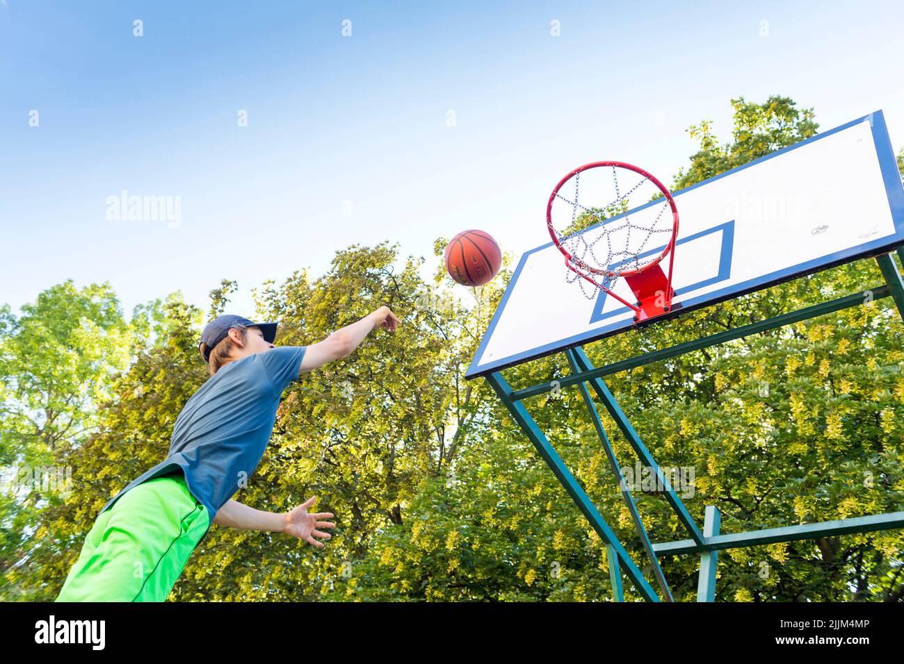 Junge spielt Basketball im Freien Stockfoto