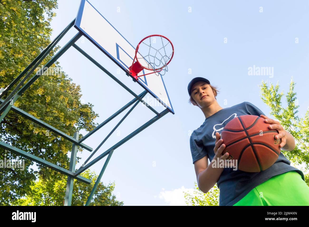 Junge spielt Basketball im Freien Stockfoto