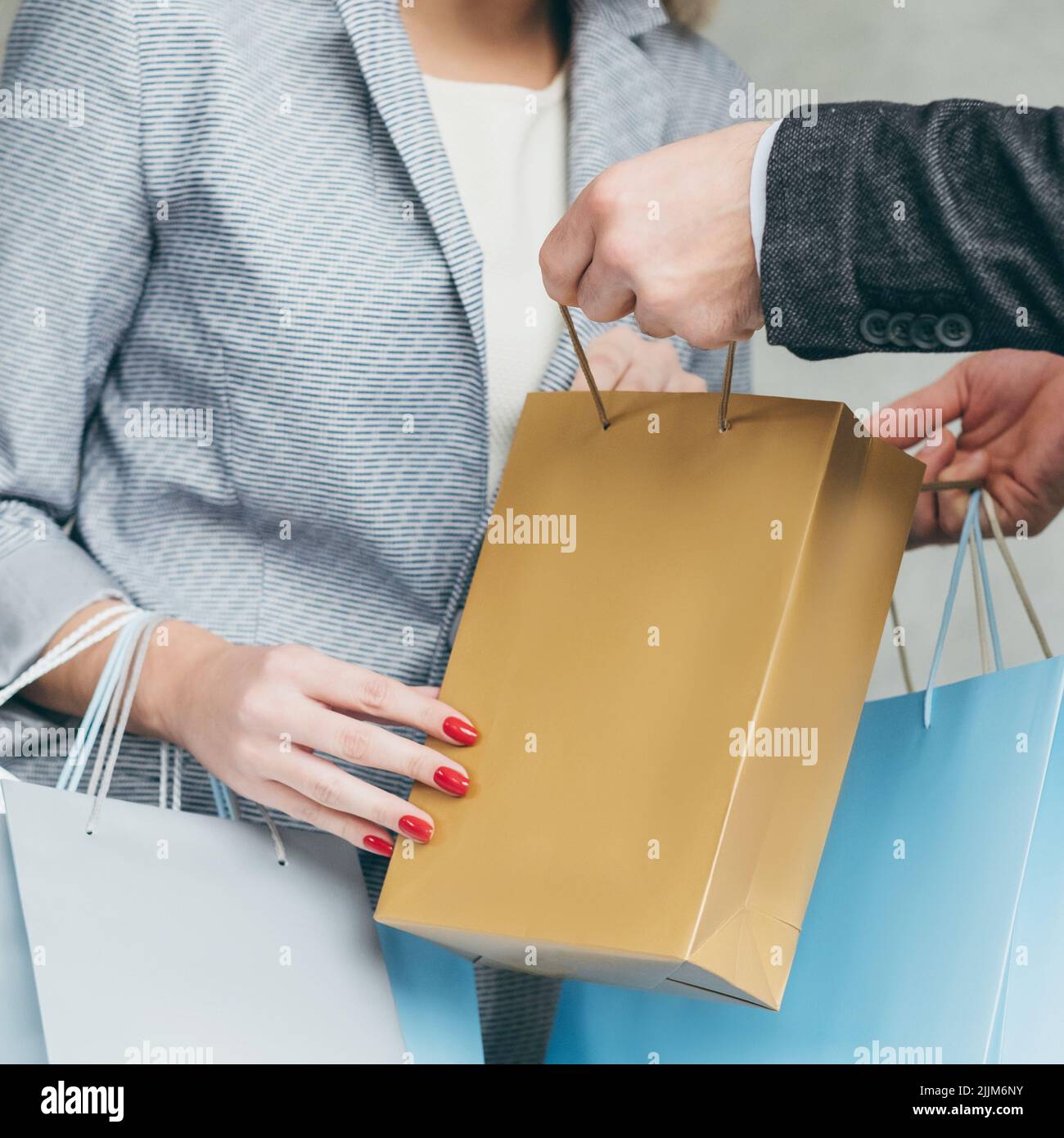 Shopping Überraschung Mann zeigen Geschenk Tasche Frau Look Stockfoto