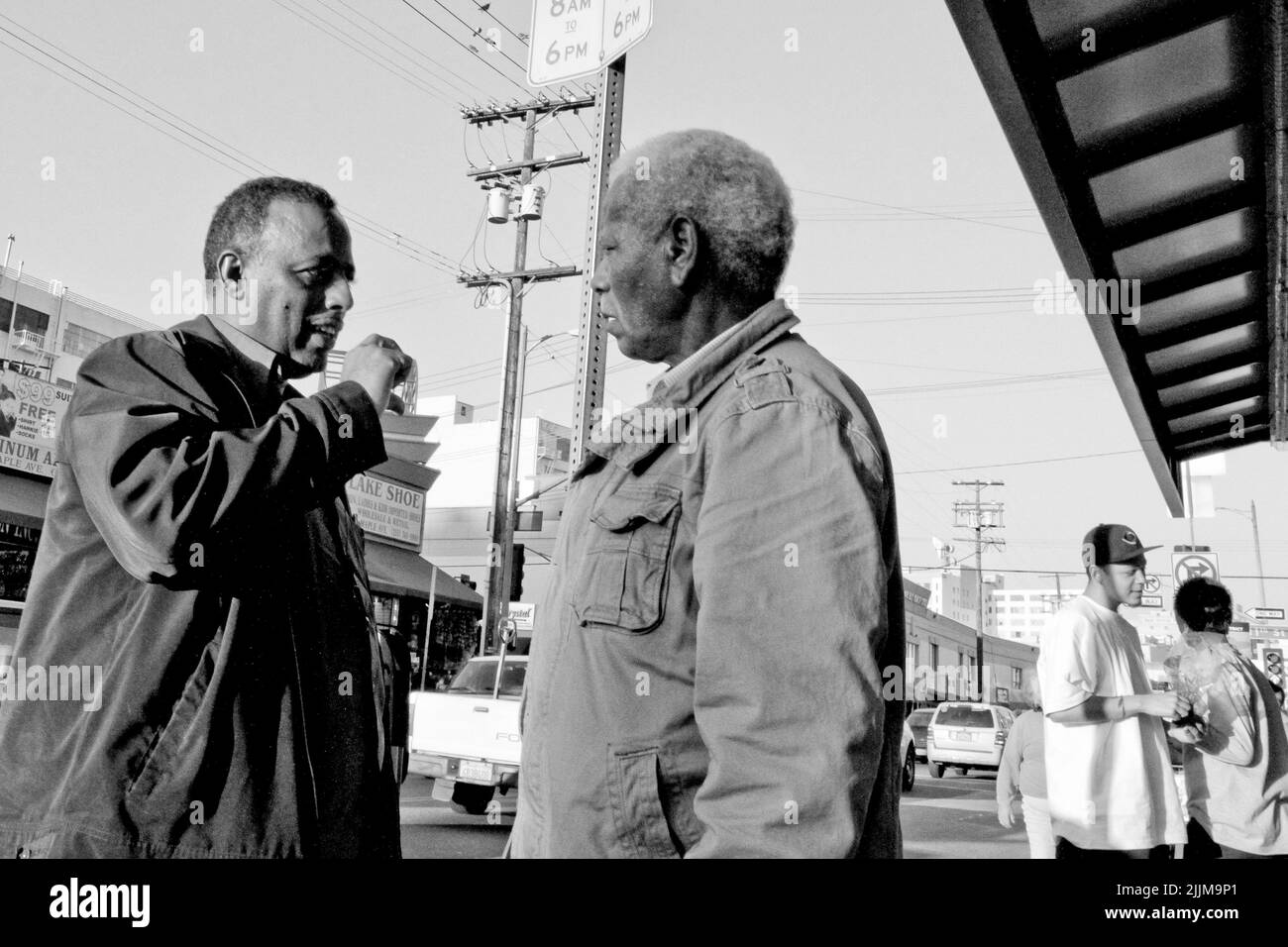 Ein oberflächlicher Fokus von zwei afroamerikanischen Männern, die auf den Straßen der Innenstadt von Los angeles, Kalifornien, aufholten Stockfoto