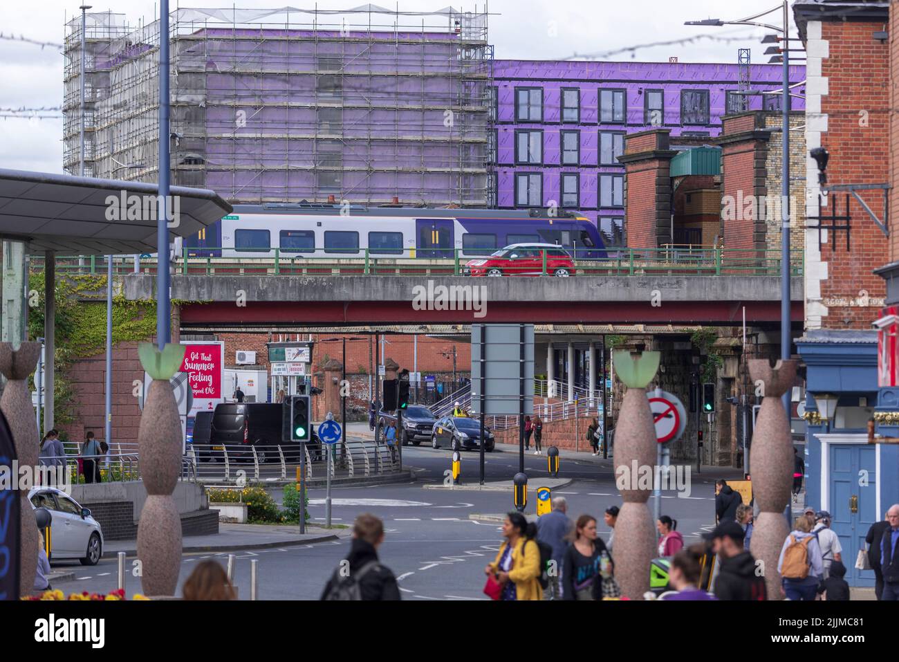 Geschäftiges Stadtzentrum in Warrington, mit dem Zug, der am Hauptbahnhof ankommt, und der Überführung durch das Zentrum. Stockfoto