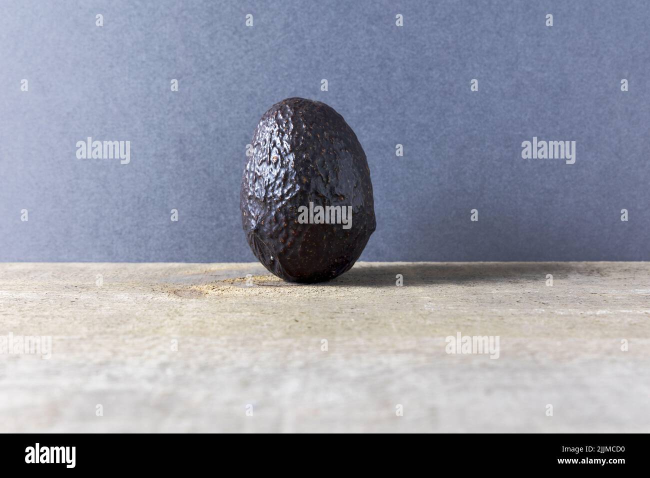 Eine große Avocado-Frucht auf einem alten Tisch bei Tageslicht Stockfoto