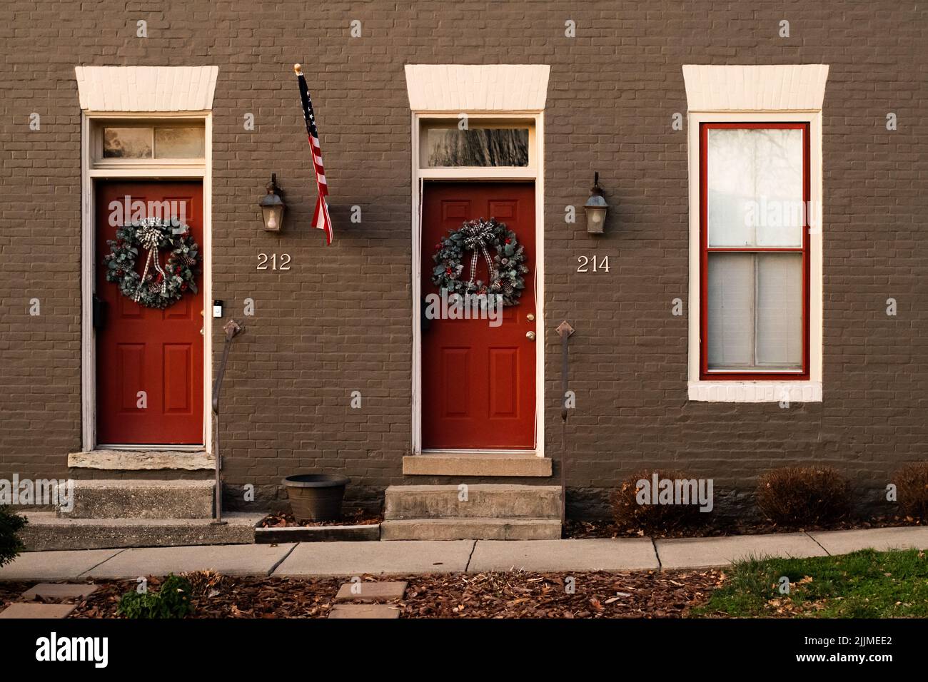 Eine braune Wand mit Türen in Weihnachtskränzen im Libanon, Ohio, USA Stockfoto