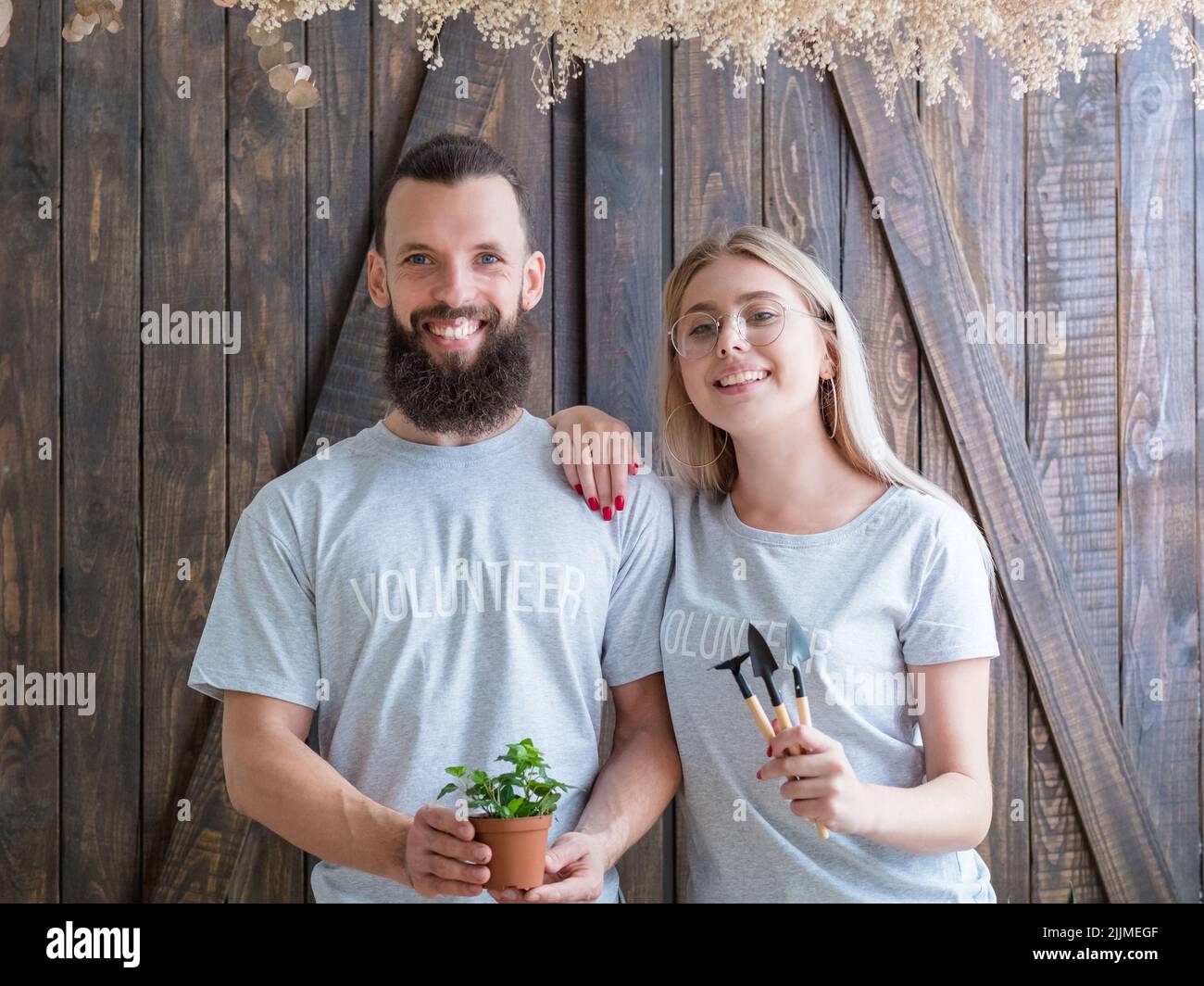 Pflanzen Freiwillige Paar halten Hauspflanzen Werkzeuge Stockfoto