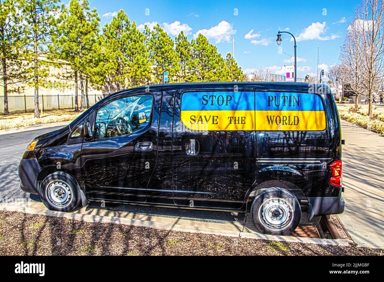 Schwarzer Mini-Van in Park in der Nähe von Bürgersteig mit Fensterschild mit der Aufschrift Stop Putin - Save the World geparkt Stockfoto