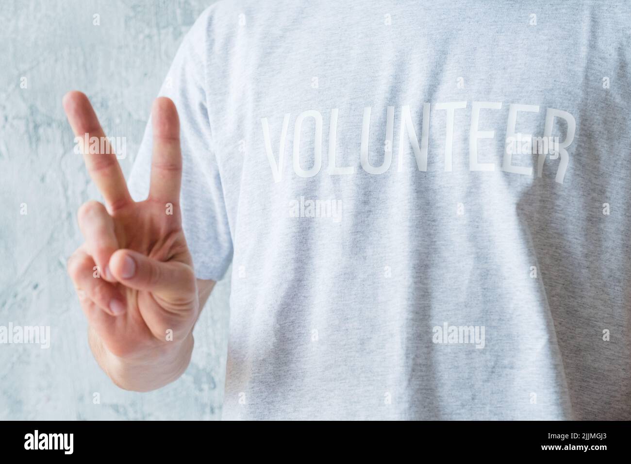 Freiwilligenarbeit modernen Lebensstil Mann zeigen V-Zeichen Stockfoto