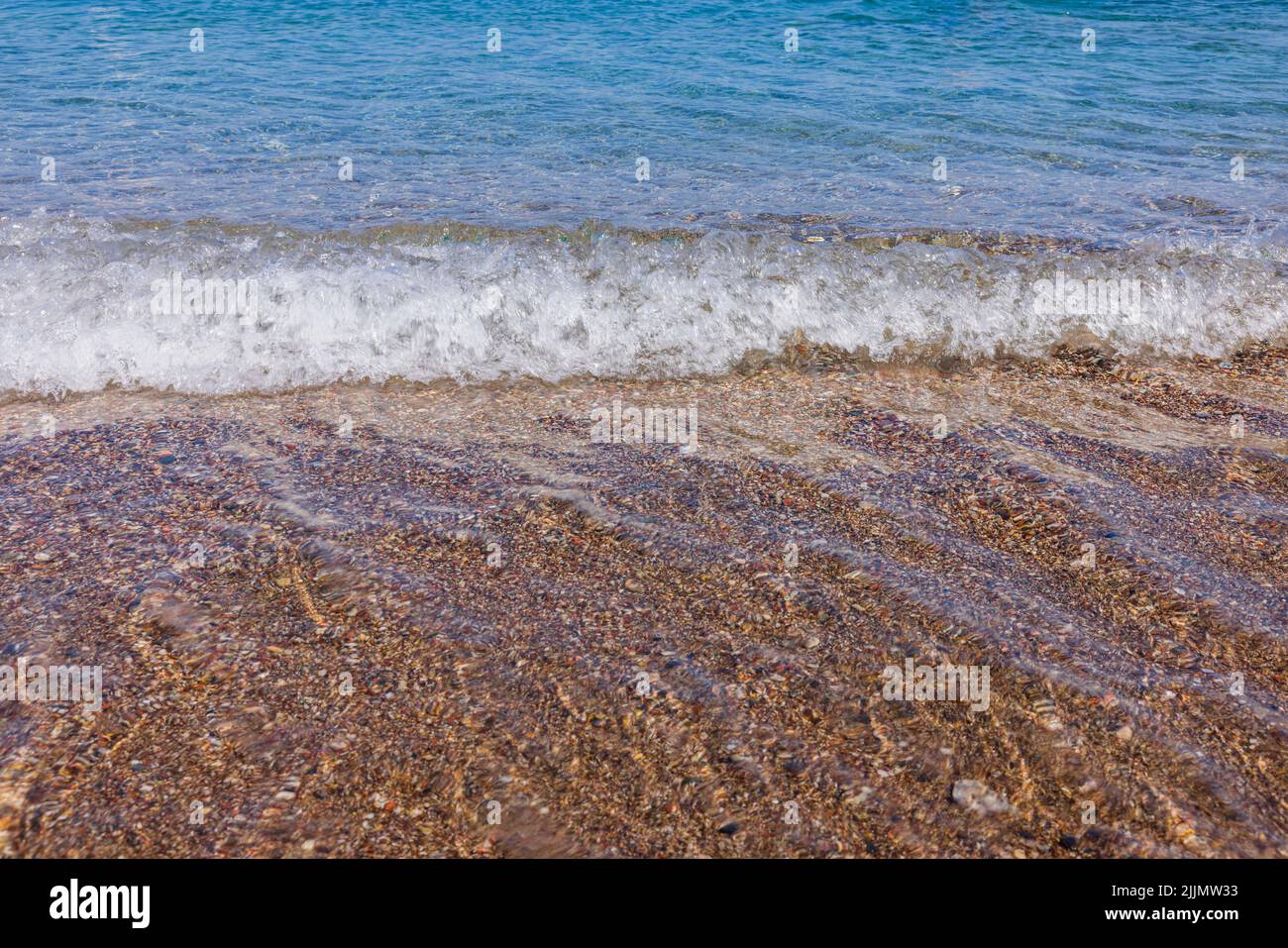Wunderschöne Aussicht auf die Wellen am Sandstrand des Meeres. Stockfoto