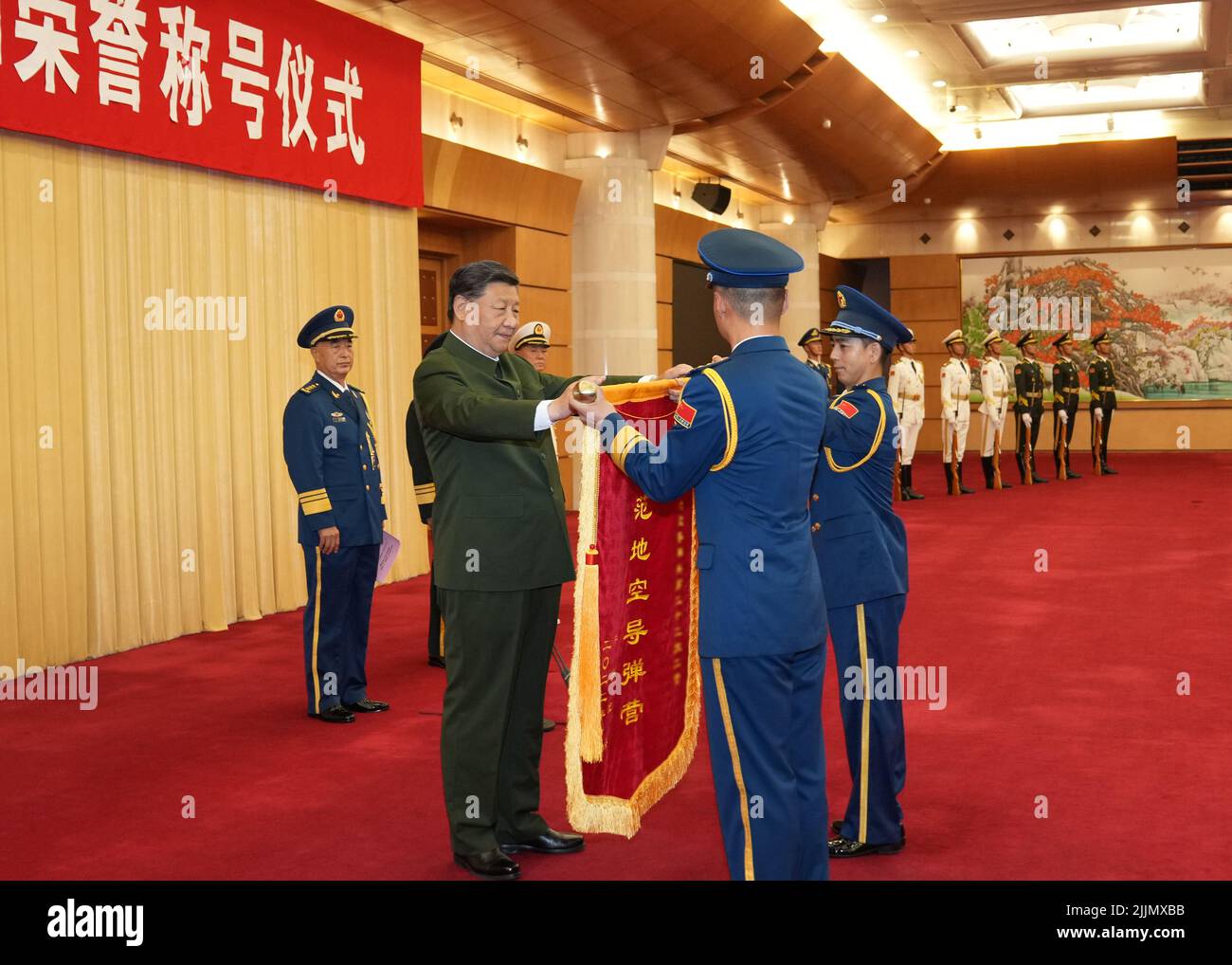 (220727) -- PEKING, 27. Juli 2022 (Xinhua) -- Der chinesische Präsident Xi Jinping, ebenfalls Generalsekretär des Zentralkomitees der Kommunistischen Partei Chinas und Vorsitzender der Zentralen Militärkommission, verleiht eine Ehrenflagge zur Verleihung eines Modellbataillons der Luftwaffe der chinesischen Volksbefreiungsarmee in Peking, der Hauptstadt Chinas, am 27. Juli 2022. XI überreichte am Mittwoch die Medaille für den 1. August an drei Militärangehörige und verlieh einem Militärbataillon eine Ehrenflagge für ihren herausragenden Dienst vor dem 95.. Jahrestag der Gründung der chinesischen Volkslib Stockfoto