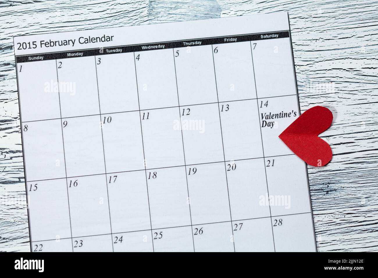 Eine Kalenderseite und ein rotes Herz-Papier am 14. Februar des Valentinstag Stockfoto