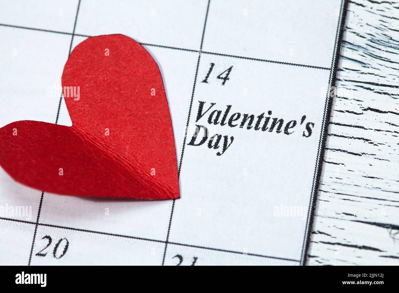 Eine Kalenderseite und ein rotes Herz-Papier am 14. Februar des Valentinstag Stockfoto