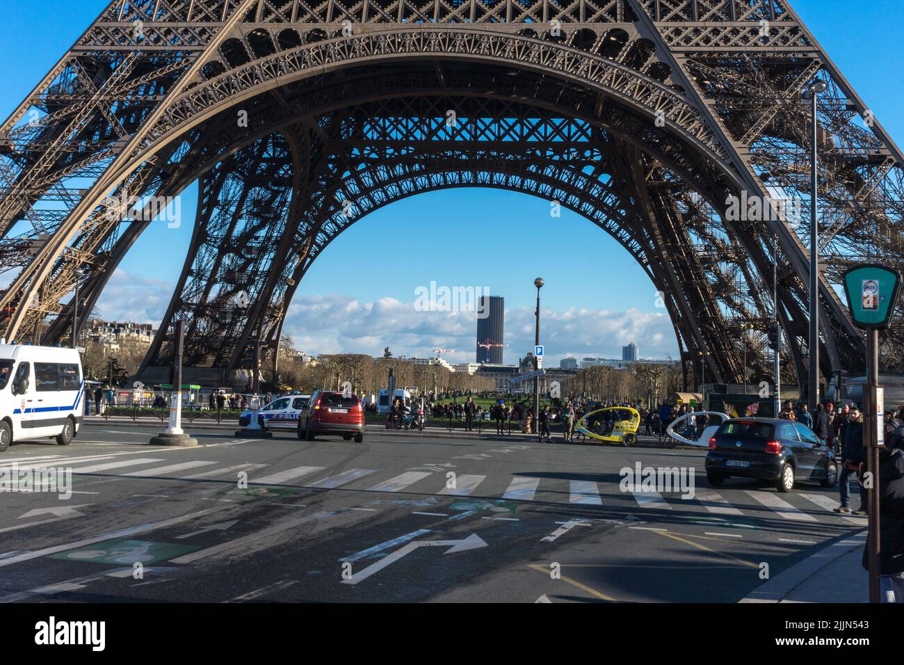 Einige Touristen stehen unter dem Ingenieurskunst-Wunder Eiffelturm in Paris. Stockfoto