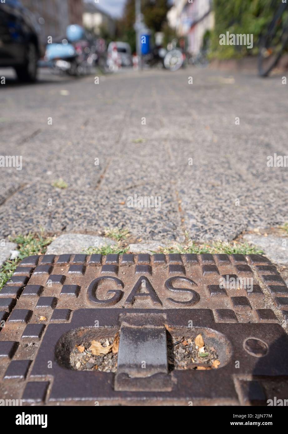 26. Juli 2022, Hessen, Frankfurt/Main: Das Wort Gas steht auf einem gusseisernen Deckel, der auf einem Bürgersteig über einer darunter liegenden Gasleitung sitzt. Foto: Frank Rumpenhorst/dpa Stockfoto