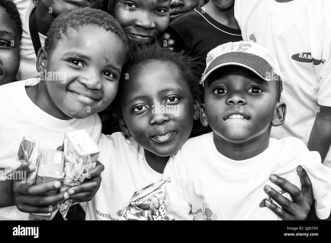 Ein Graustufenporträt afrikanischer Kinder, die auf dem Schulhof in Johannesburg, Südafrika, posieren Stockfoto