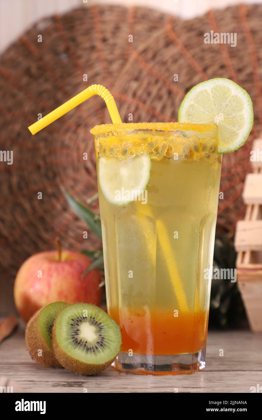 Ein Stillleben mit einer erfrischenden Limonade mit Passionsfrucht, die mit Zitrone, Kiwi und Apfel dekoriert ist Stockfoto