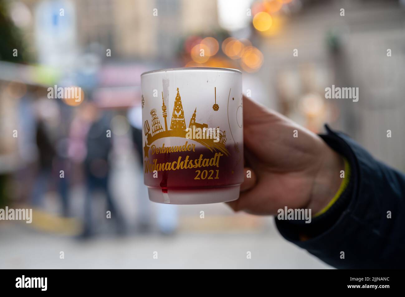 Eine Nahaufnahme der Hand mit einer Teetasse mit Text weihnachtsstadt auf Deutsch. Dortmunder Weihnachtsmarkt. Stockfoto
