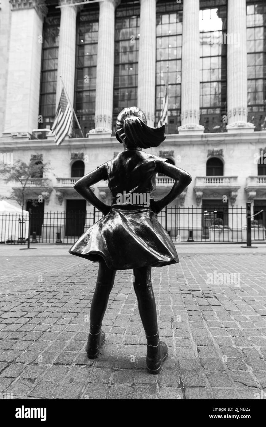 NEW YORK CITY, USA - 29. NOVEMBER 2021: Fearless Girl Statue blickt auf das New Yorker Börsengebäude an der Wall Street Stockfoto