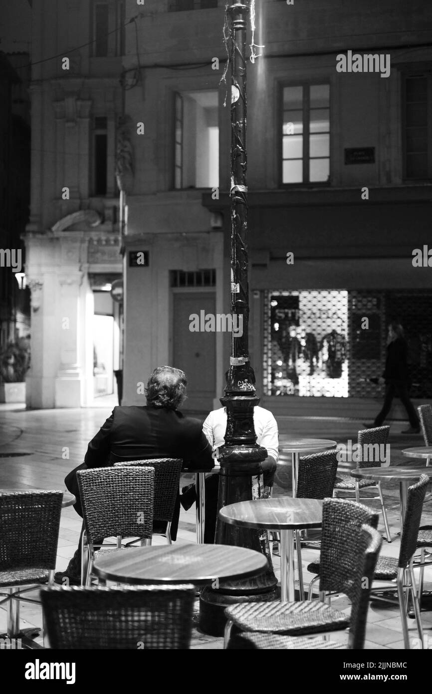 Eine Graustufe von ein paar Männern, die in einer Bar in Frankreich einen Drink zu sich nehmen Stockfoto