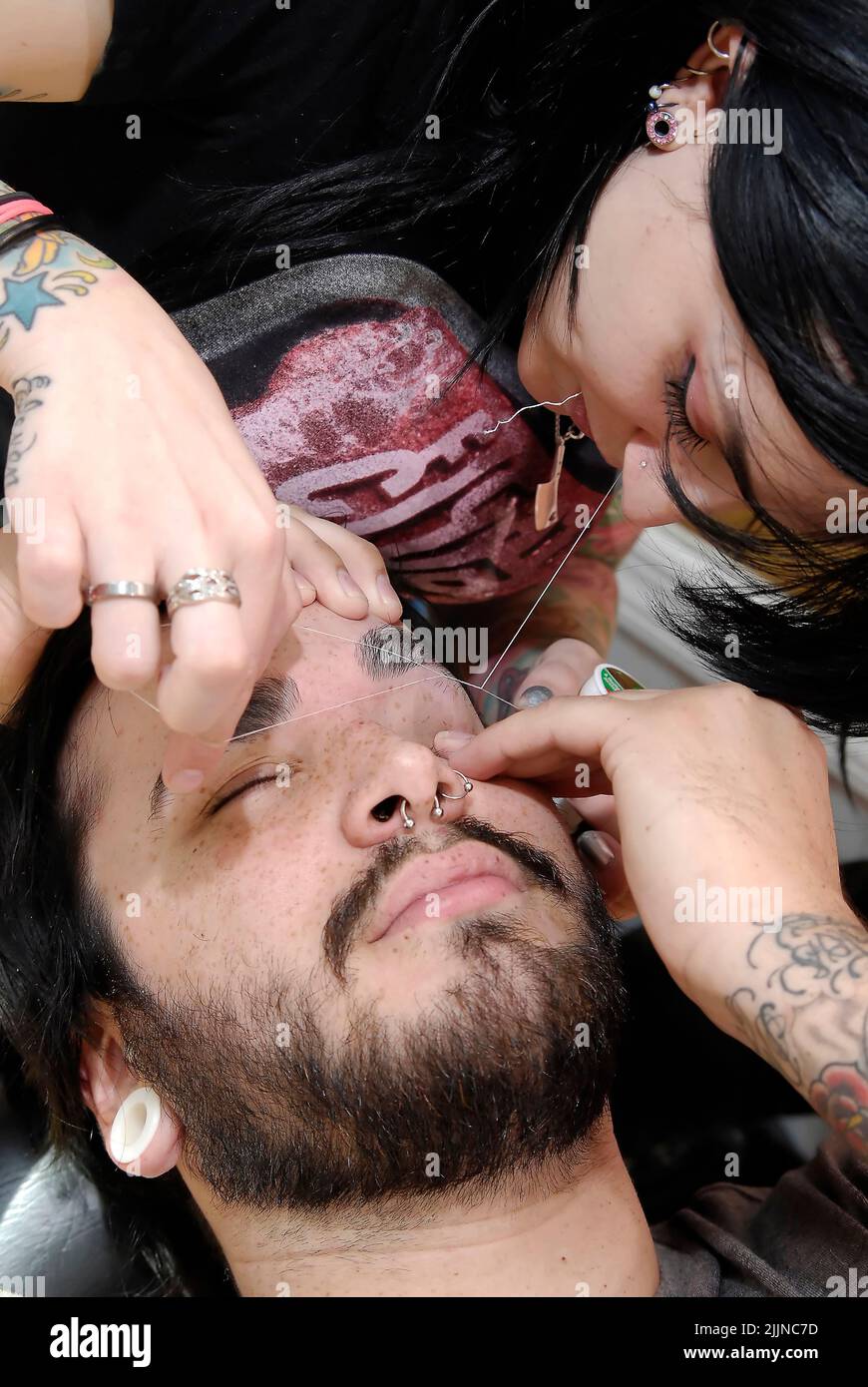 Ein junger Mann, der in einem Salon in Saint Louis, Missouri, USA, seine Augenbrauen genäht bekommt. Stockfoto