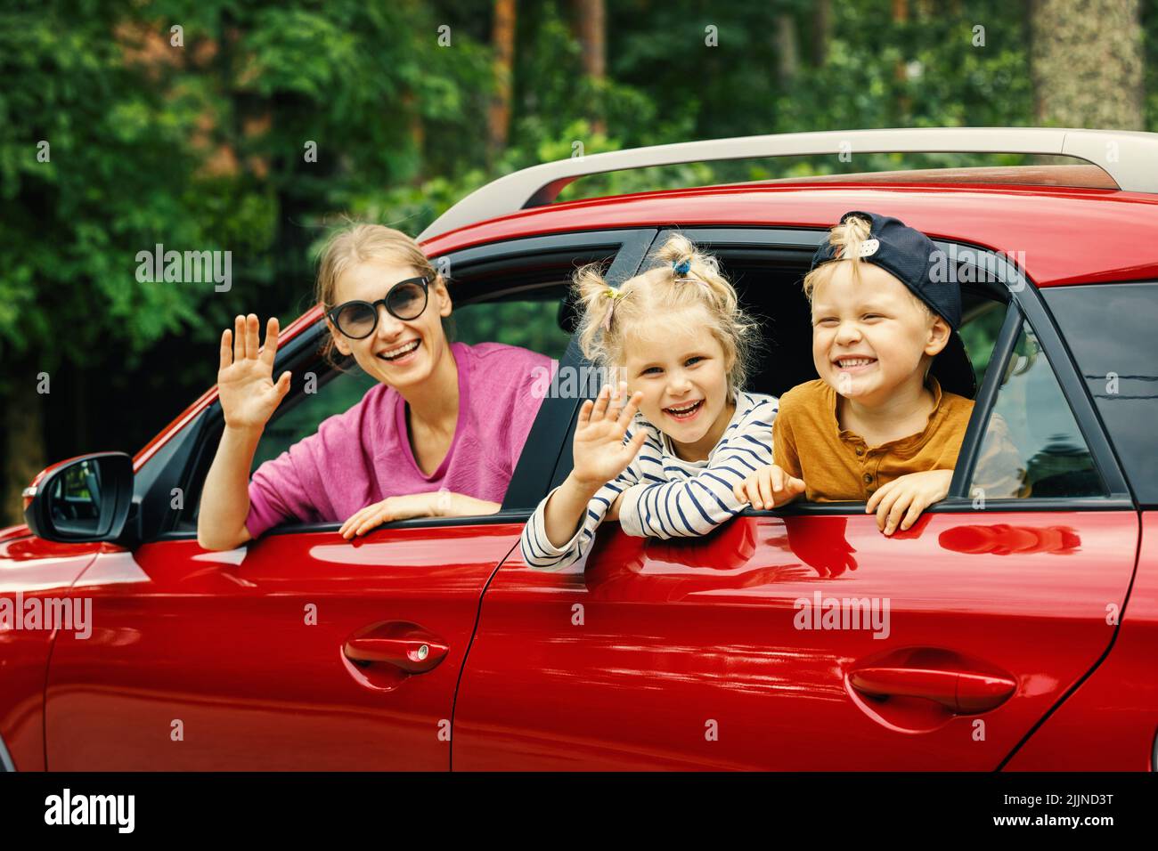 Familienausflug. Mutter mit Kindern, die mit dem Auto reisen. Sich aus dem Fenster lehnen Stockfoto