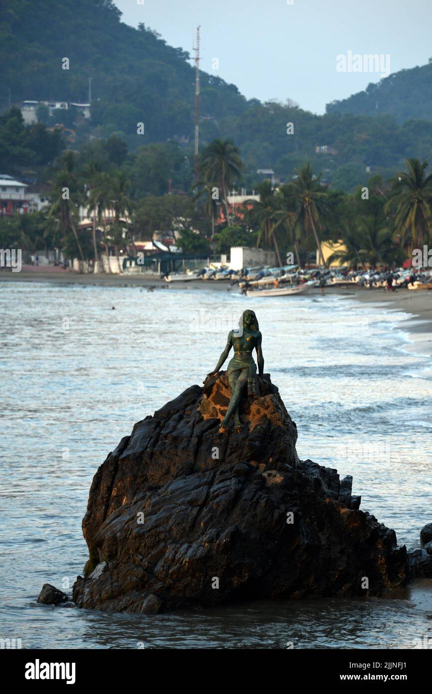 Eine vertikale Aufnahme der Statue eines Weibchens an der Küste, die Acapulco in Zihuatanejo, Mexiko, darstellt Stockfoto