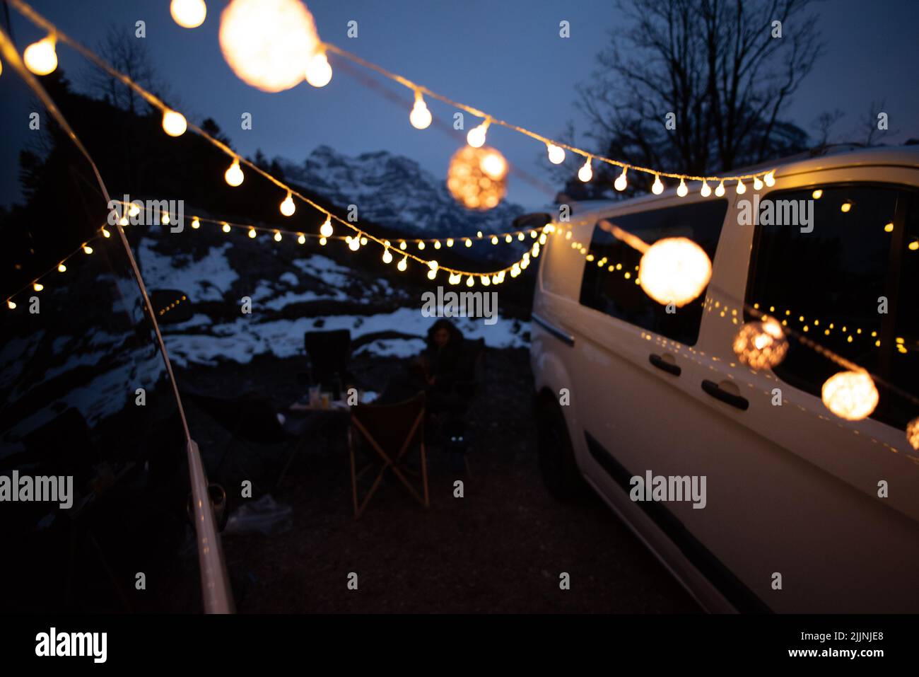 Ein weißes Auto stand auf einem Feld mit Lampen, die an Seilen befestigt waren Stockfoto