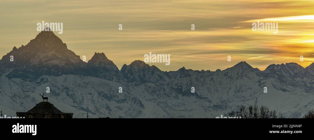 Die Jagdhütte von Stupinigi gegen den verschneiten Monte Viso während des Sonnenuntergangs Stockfoto