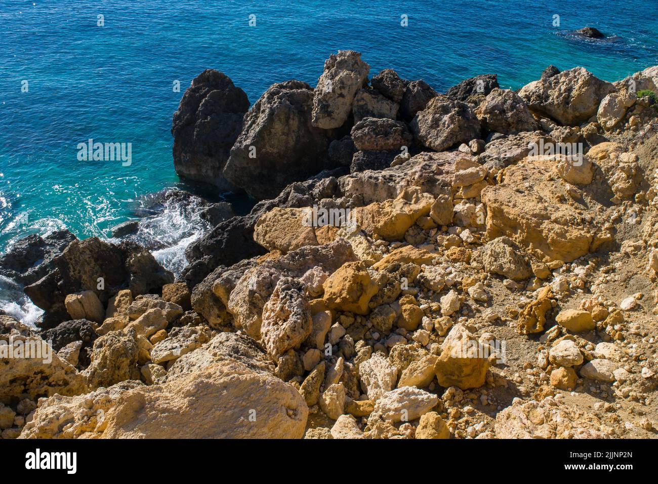 Ein Geröll aus Kalksteinfelsen und -Steinen, die sich entlang der Küste von Gozo, Malta, infolge der Verwitterung und Erosion der Küstenmeeres auftürmten. Stockfoto