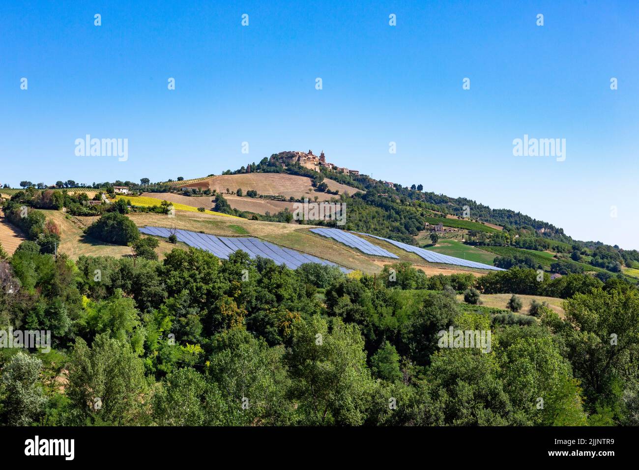 Solarzellen auf den grünen Hügeln des Dorfes Montedinove auf einer Höhe von 561 m in der italienischen Region Marken. Stockfoto
