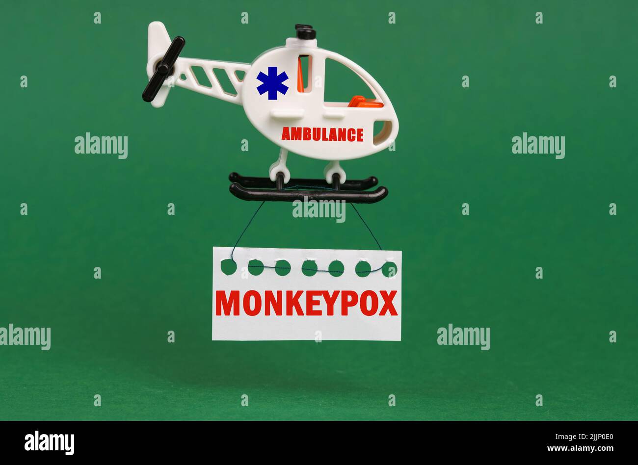 Medizinisches Konzept. Auf einer grünen Oberfläche, ein Rettungshubschrauber mit einem Schild - monkeypox Stockfoto