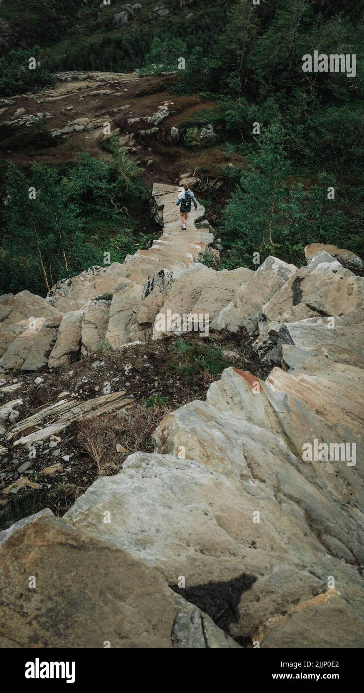 Vertikale Aufnahme eines Mannes, der vom Berg die Treppe hinunter ging Stockfoto