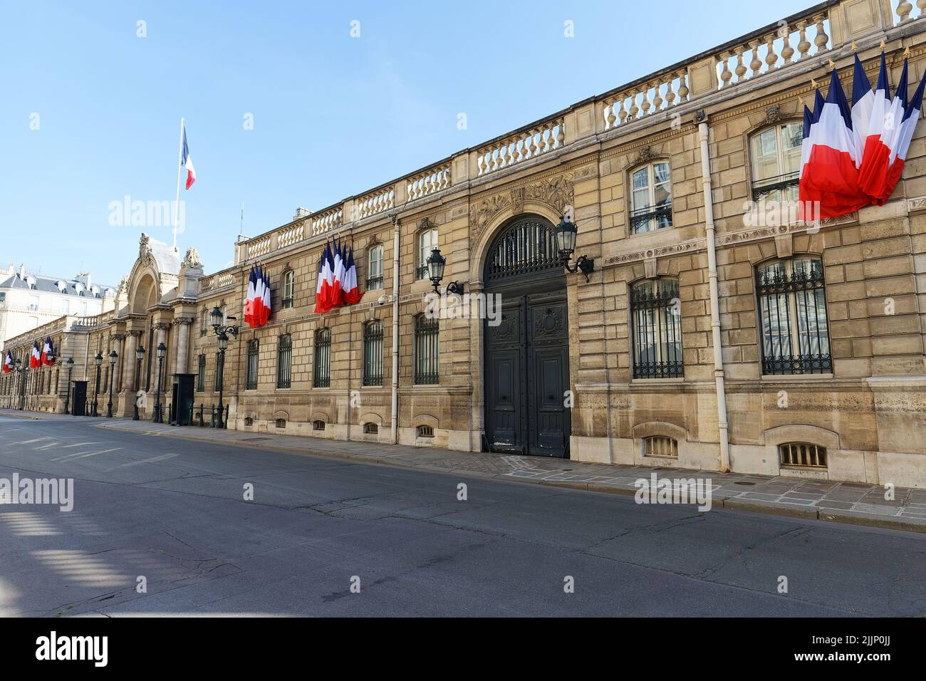 Blick auf das Eingangstor des Elysee-Palastes mit Nationalflaggen. Elysee Palace - offizielle Residenz des Präsidenten der Französischen Republik seit Stockfoto