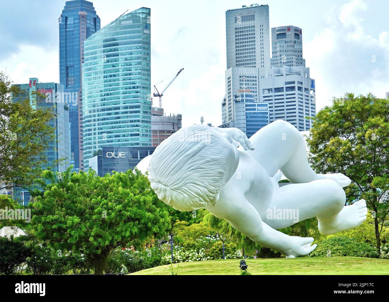 Ein heller Sommertag an der schwimmenden Babystatue im Marina Park, Singapur, umgeben von Grün Stockfoto