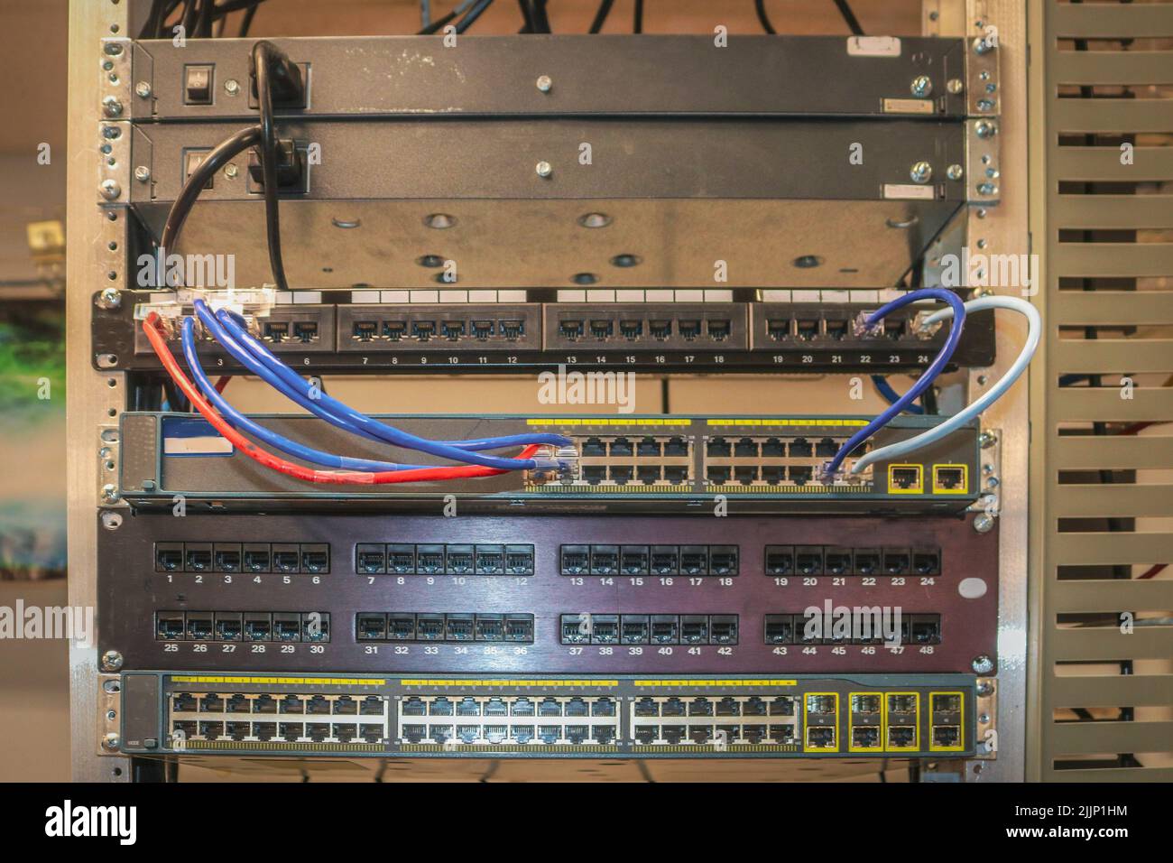 Patchpanels, die in einem Netzwerk-Rack installiert sind, in dem LAN-Switches installiert werden Stockfoto Patchpanels, die in einem Netzwerk-Rack installiert sind, in dem LAN-Switches installiert werden Stockfoto