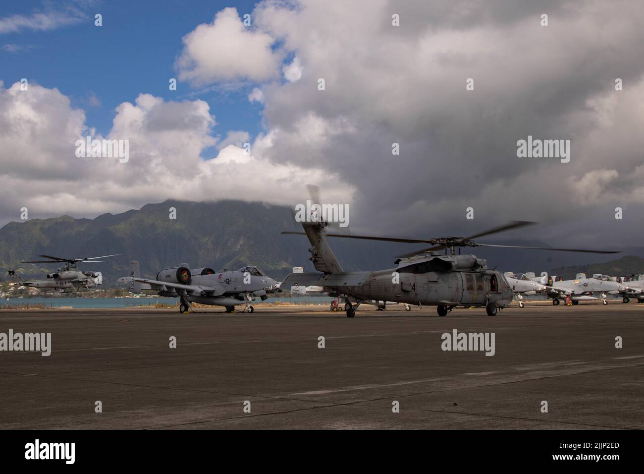 MARINE CORPS AIR STATION KANEOHE BAY, Hawaii (22. Juli 2022) Ein U.S. Marine Corps AH-1 Super Cobra und die U.S. Navy MH-60s Seahawk verlassen Marine Corps Air Station Kaneohe Bay, Hawaii, um an einer Sink Exercise (SINKEX) während des Rim of the Pacific (RIMPAC) 2022 teilzunehmen. RIMPAC-Streitkräfte feuerten während einer SINKEX auf die stillgelegte ehemalige USS Denver (LPD 9), Juli 22, und versenkten diese, um sich in der Taktik zu beherrschen, zielte und feuerte live gegen ein Oberflächenziel auf See. SINKEX-Behälter werden einem zertifizierten Reinigungsprozess durchlaufen, einschließlich der Entfernung aller umweltschädlichen Materialien einschließlich Müll, f Stockfoto