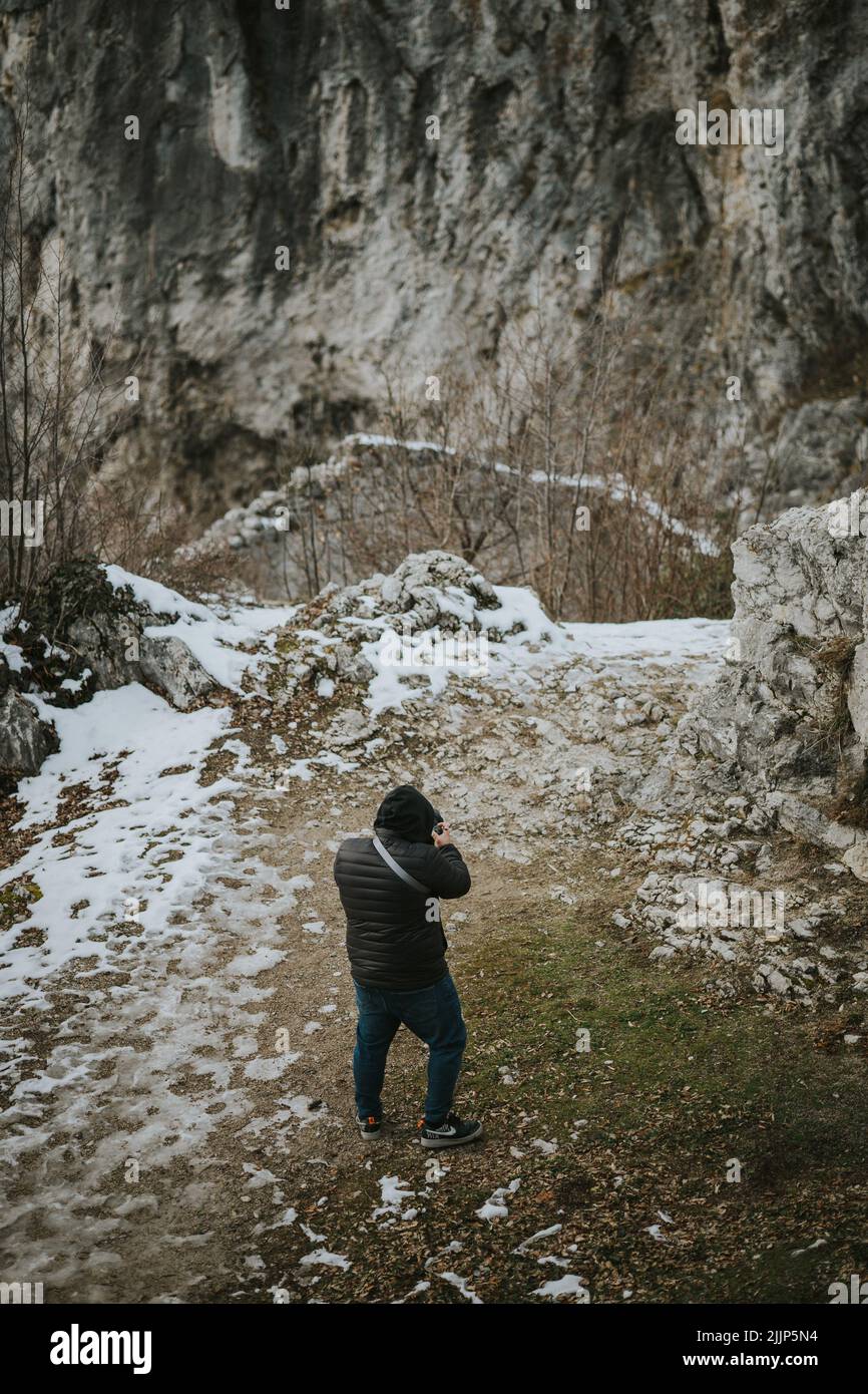 Ein junger Tourist, der im Winter mit seiner Kamera fotografiert Stockfoto