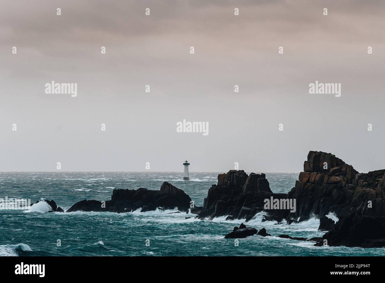 Eine wunderschöne Landschaft mit Wellen, Felsen und einem Leuchtturm in der Normandie, Nordfrankreich Stockfoto