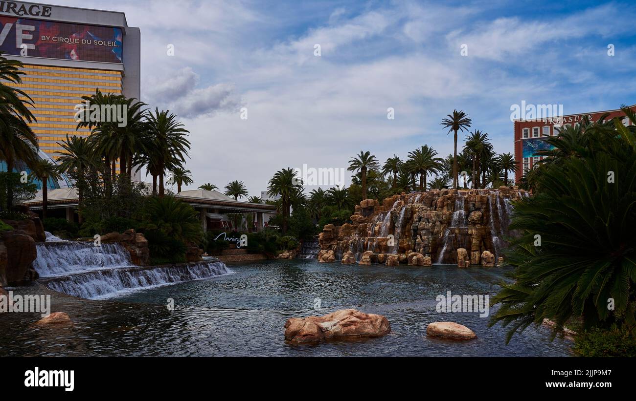Der legendäre Vulkan Mirage, umgeben von Wasser in Las Vegas unter blauem, strahlendem Himmel Stockfoto